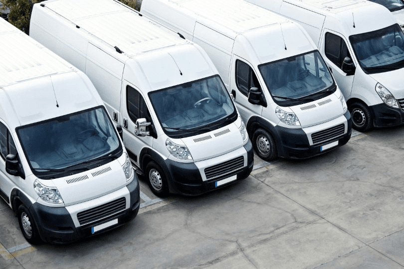 Fleet of white fire protection service vans parked in a row