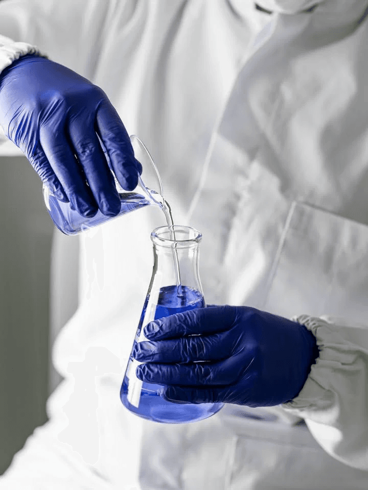 Lab technician pouring liquid into a flask during scientific work